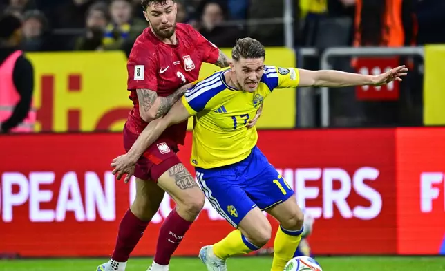 Poland's Przemyslaw Wisniewski, left, and Sweden's Viktor Gyokeres during a World Cup qualifying playoff final soccer match between Sweden and Poland in Stockholm, Tuesday, March 31, 2026. (Jonas Ekstromer/TT via AP)