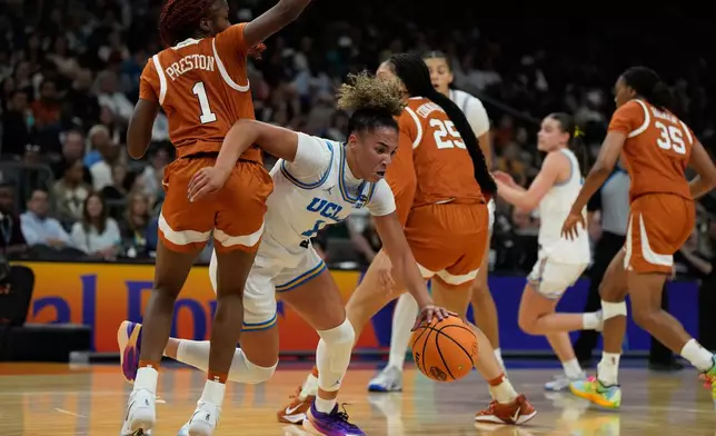 UCLA guard Kiki Rice (1) drives against Texas guard Bryanna Preston, left, during the first half of a women's NCAA college basketball tournament semifinal game at the Final Four, Friday, April 3, 2026, in Phoenix. (AP Photo/Ross D. Franklin)
