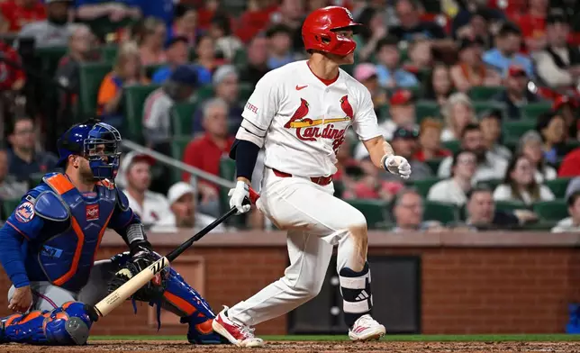 St. Louis Cardinals' JJ Wetherholt, right, watches his single next to New York Mets catcher Luis Torrens in the third inning of a baseball game, Tuesday, March 31, 2026, in St. Louis. (AP Photo/Joe Puetz)