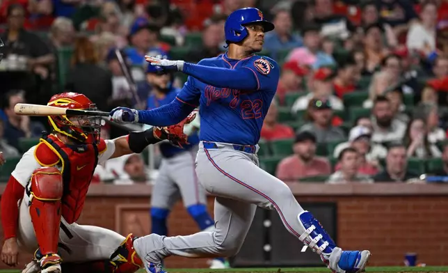 New York Mets' Juan Soto (22) watches his double next to St. Louis Cardinals catcher Ivan Herrera in the sixth inning of a baseball game, Tuesday, March 31, 2026, in St. Louis. (AP Photo/Joe Puetz)