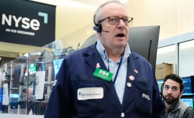 People work on the floor at the New York Stock Exchange in New York, Monday, April 13, 2026. (AP Photo/Seth Wenig)