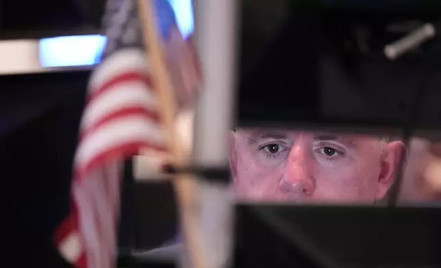 People work on the floor at the New York Stock Exchange in New York, Monday, April 13, 2026. (AP Photo/Seth Wenig)