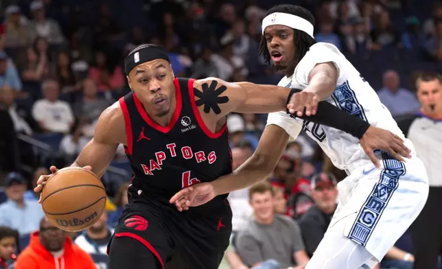Toronto Raptors forward Scottie Barnes, left, drives to the basket while defended by Memphis Grizzlies guard Adama Bal, right, during the first half of an NBA basketball game Friday, April 3, 2026, in Memphis, Tenn. (AP Photo/Nikki Boertman)