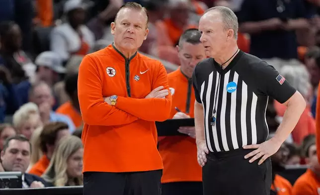 Illinois coach Brad Underwood listens to an official during a timeout to fix a broken horn during the first half of an Elite Eight game against Iowa in the NCAA college basketball tournament Saturday, March 28, 2026, in Houston. (AP Photo/Ashley Landis)