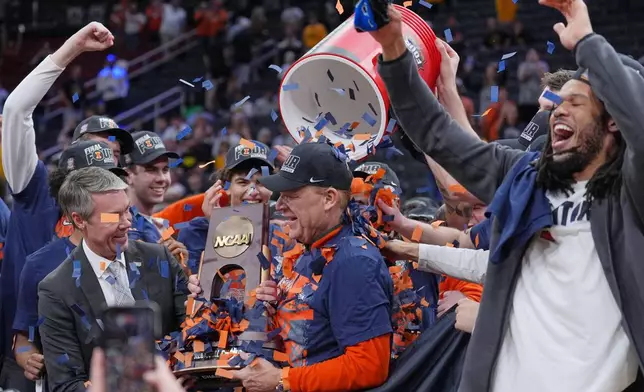 Illinois coach Brad Underwood celebrates with players after an Elite Eight game against Iowa in the NCAA college basketball tournament Saturday, March 28, 2026, in Houston. (AP Photo/Eric Gay)