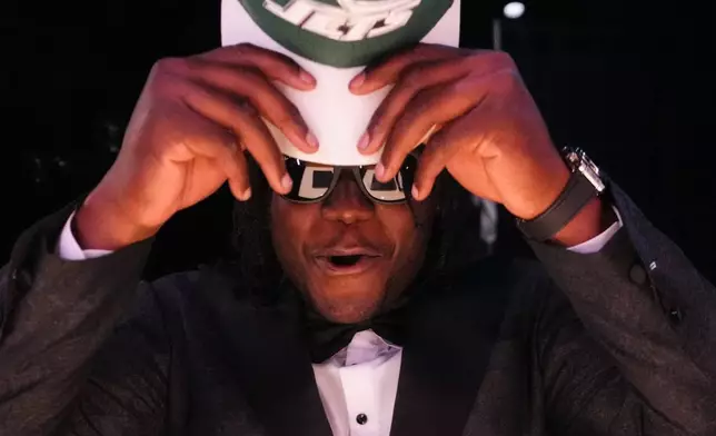 Texas Tech linebacker David Bailey puts on a hat after being chosen by the New York Jets with the second overall pick during the first round of the NFL football draft, Thursday, April 23, 2026, in Pittsburgh. (AP Photo/Jeff Roberson)