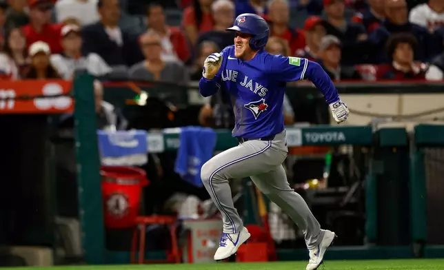 Toronto Blue Jays' Myles Straw (3) runs to home plate to score during the seventh inning of a baseball game against the Los Angeles Angels, Monday, April 20, 2026, in Anaheim, Calif. (AP Photo/Caroline Brehman)