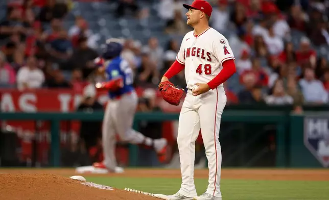 Los Angeles Angels starting pitcher Reid Detmers (48) looks on as Toronto Blue Jays' Vladimir Guerrero Jr. (27) rounds the bases after hitting a two-run home run during the third inning of a baseball game Monday, April 20, 2026, in Anaheim, Calif. (AP Photo/Caroline Brehman)