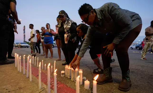 People light candles during a prayer vigil for the victims of a mass shooting earlier in the day, Sunday, April 19, 2026, in Shreveport, La. (AP Photo/Gerald Herbert)