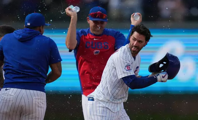 Chicago Cubs' Dansby Swanson, right, celebrates with teammates after driving in the game-winning run in the 10th inning of a baseball game against the Philadelphia Phillies, Thursday, April 23, 2026, in Chicago. (AP Photo/Erin Hooley)