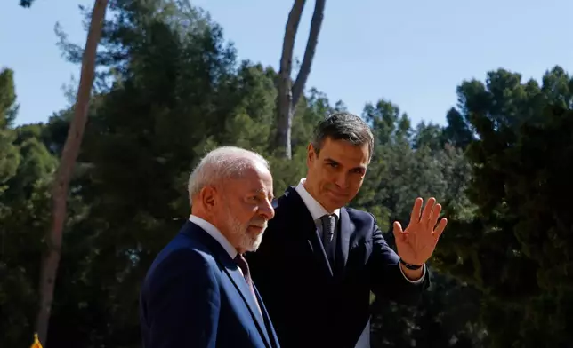 Spain's Prime Minister Pedro Sanchez, right, waves next to Brazil's President Luiz Inacio Lula da Silva during a Spain-Brazil summit in Barcelona, Spain, Friday, April 17, 2026. (AP Photo/Joan Monfort)