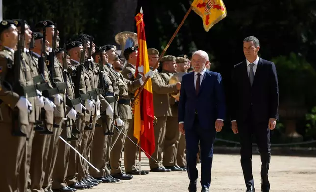 Spain's Prime Minister Pedro Sanchez, right, and Brazil's President Luiz Inacio Lula da Silva review troops during a Spain-Brazil summit in Barcelona, Spain, Friday, April 17, 2026. (AP Photo/Joan Monfort)
