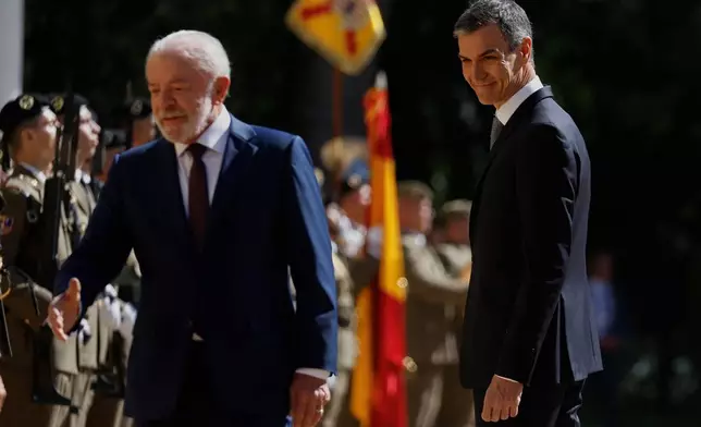 Spain's Prime Minister Pedro Sanchez, right, and Brazil's President Luiz Inacio Lula da Silva review troops during a Spain-Brazil summit in Barcelona, Spain, Friday, April 17, 2026. (AP Photo/Joan Monfort)
