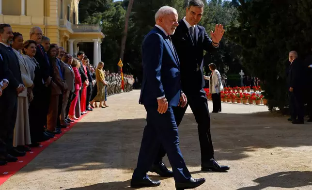 Spain's Prime Minister Pedro Sanchez, right, waves nesxt to Brazil's President Luiz Inacio Lula da Silva during a Spain-Brazil summit in Barcelona, Spain, Friday, April 17, 2026. (AP Photo/Joan Monfort)