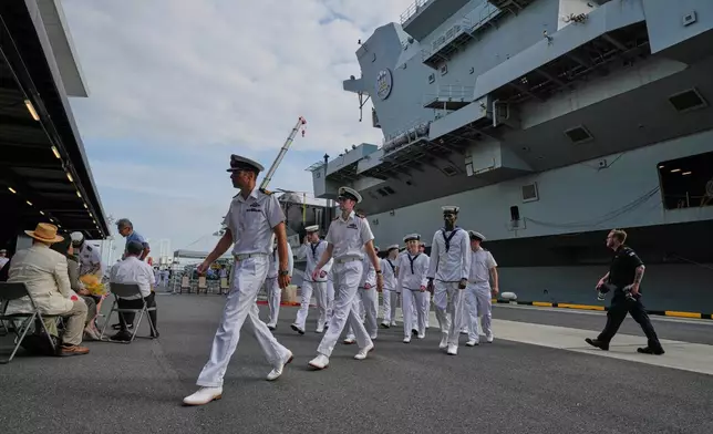 FILE - Crews walk near the Royal Navy aircraft carrier HMS Prince of Wales before its port call in Tokyo Thursday, Aug. 28, 2025. (AP Photo/Eugene Hoshiko, File)