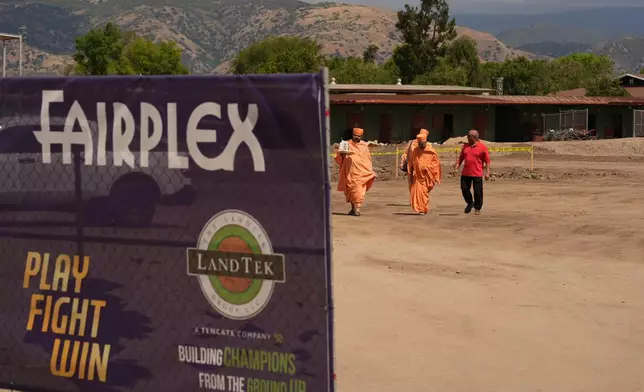 BAPS Shri Swaminarayan Mandir temple Hindu monks walk after performing a Puja ceremony, a traditional blessing ritual for the groundbreaking ceremony for the official home field for the Los Angeles Knight Riders for 2026, and the future venue of the LA 2028 Olympics Fairgrounds Cricket Stadium at the Pomona Fairplex in Pomona, Calif., Wednesday, April 22, 2026. (AP Photo/Damian Dovarganes)
