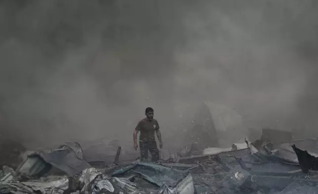 A first responder emerges through the smoke at the site of an Israeli airstrike that struck an apartment building in Beirut, Lebanon, Wednesday, April 8, 2026. (AP Photo/Bilal Hussein)