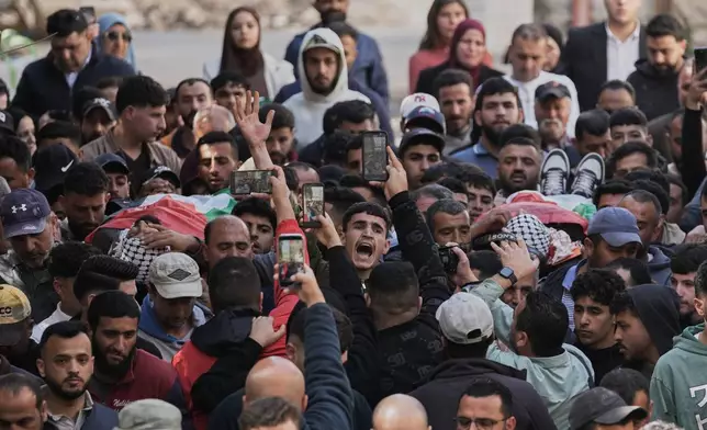 Mourners carry the bodies of Aws al-Na'san and Jihad Abu Naim, residents of the West Bank village of al-Mughayyir, out of the hospital's morgue in the West Bank city of Ramallah, Tuesday, April 21, 2026. (AP Photo/Mahmoud Illean)