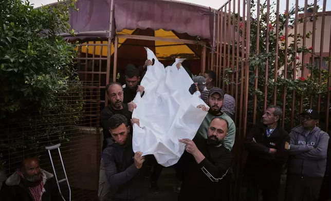 Palestinians carry the body of Majed Abu Mousa, who was killed in an Israeli strike, during his funeral at Nasser Hospital in Khan Younis, southern Gaza Strip, Tuesday, April 21, 2026. (AP Photo/Abdel Kareem Hana)