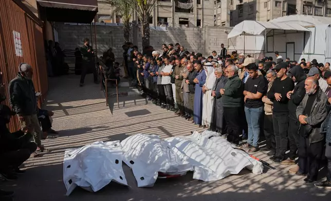 Palestinians pray beside the bodies of men killed in an Israeli strike, during their funeral at Nasser Hospital in Khan Younis, southern Gaza Strip, Tuesday, April 21, 2026.(AP Photo/Abdel Kareem Hana)