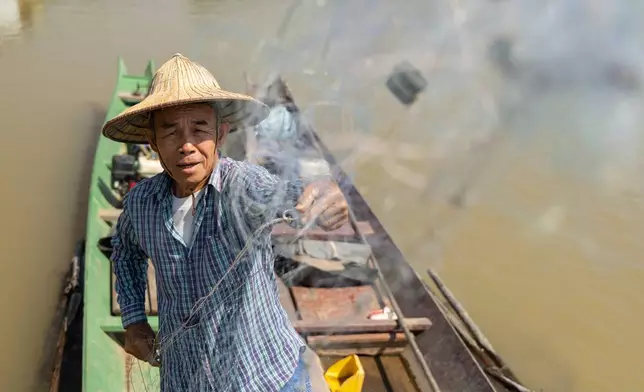 Fisherman Sukjai Yana untangles his net while docked on the Kok River in Chiang Saen, Thailand, on Feb. 17, 2026. (AP Photo/Anton L. Delgado)