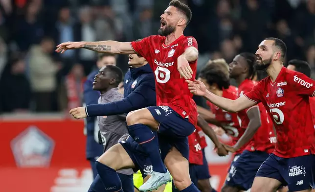 Lille's Olivier Giroud, center, celebrates with teammates at the end of the French League One soccer match between Lille and Lens, in Lille, France, Saturday, April 4, 2026. (AP Photo/Jean-Francois Badias)
