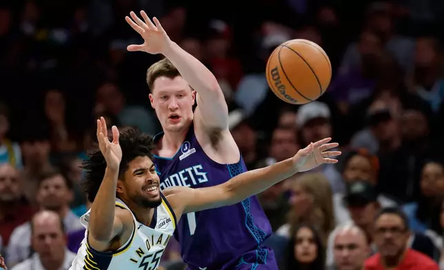 Indiana Pacers guard Ethan Thompson (55) battles Charlotte Hornets guard Kon Knueppel, right, for the ball during the first half of an NBA basketball game in Charlotte, N.C., Friday, April 3, 2026. (AP Photo/Nell Redmond)