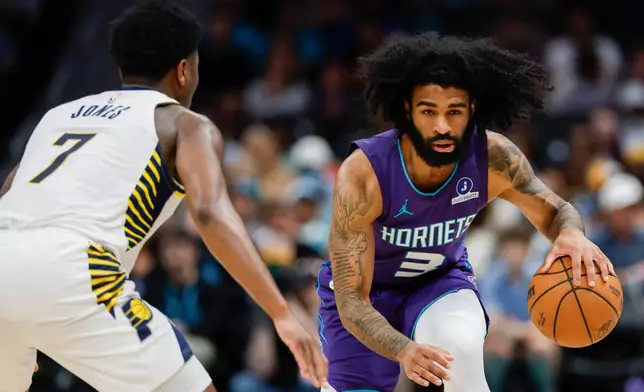 Charlotte Hornets guard Coby White (3) moves the ball against Indiana Pacers guard Kam Jones (7) during the first half of an NBA basketball game in Charlotte, N.C., Friday, April 3, 2026. (AP Photo/Nell Redmond)