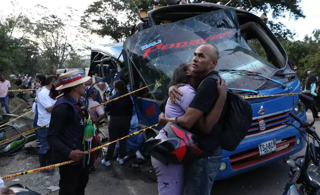 Relatives of victims embrace in front of a bus hit by an explosive device on the Pan-American Highway in Cajibio, Colombia, Saturday, April 25, 2026, after an attack blamed by authorities on dissident groups of the former FARC rebels killed at least a dozen people. (AP Photo/Santiago Saldarriaga)