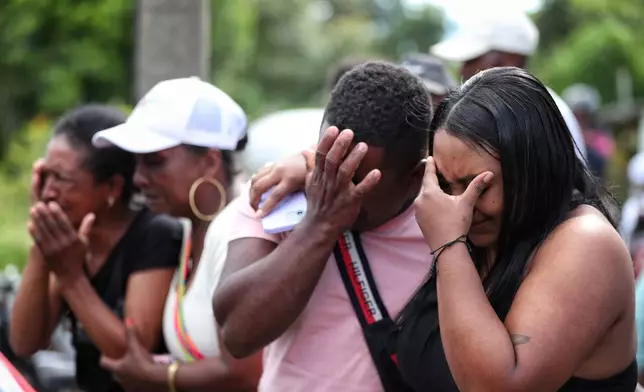 Relatives of a victim of an attack that killed at least 20 people on the Pan-American Highway, which authorities blamed on dissident former FARC rebels, cry during a funeral in Cajibio, Colombia, Monday, April 27, 2026. (AP Photo/Santiago Saldarriaga)