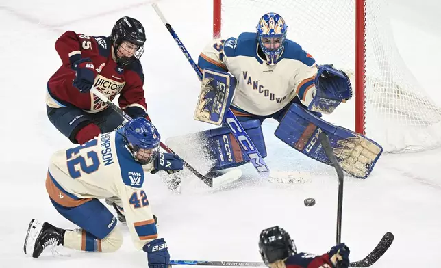 Montreal Victoire's Dara Greig (17) takes a shot on Vancouver Goldeneyes goaltender Emerance Maschmeyer (38) as Goldeneyes' Claire Thompson (42) and Victoire's Lina Ljungblom (25) look for a rebound during second period PWHL hockey game in Laval, Que., Wednesday, April 1, 2026. (Graham Hughes/The Canadian Press via AP)