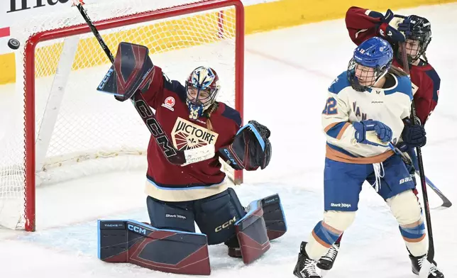 Montreal Victoire goaltender Ann-Renee Desbiens (35) deflects the puck as Victoire's Jessica DiGirolamo (22) defends against Vancouver Goldeneyes' Jenn Gardiner (12) during second period PWHL hockey game in Laval, Que., Wednesday, April 1, 2026. (Graham Hughes/The Canadian Press via AP)
