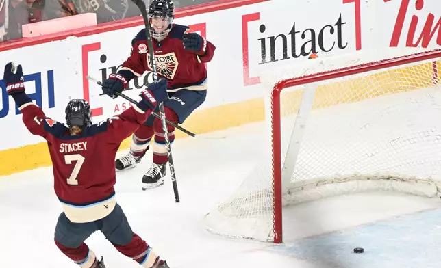 Montreal Victoire's Hayley Scamurra (16) celebrates with teammate Laura Stacey (7) after scoring an empty net goal against the Vancouver Goldeneyes during third period PWHL hockey action in Laval, Que., Wednesday, April 1, 2026. (Graham Hughes/The Canadian Press via AP)