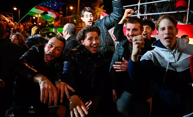 People celebrate in the streets following the announcement of the partial results of the parliamentary election, in Budapest, Hungary, Sunday, April 12, 2026. (AP Photo/Denes Erdos)