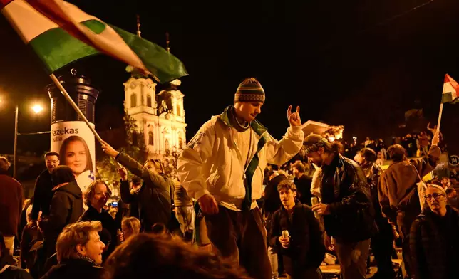 Youngsters celebrate in Budapest, Hungary, Monday, April 13, 2026, after Peter Magyar's Tisza party defeated Prime Minister Viktor Orban's Fidesz party in the country's parliamentary elections. (AP Photo/Denes Erdos)