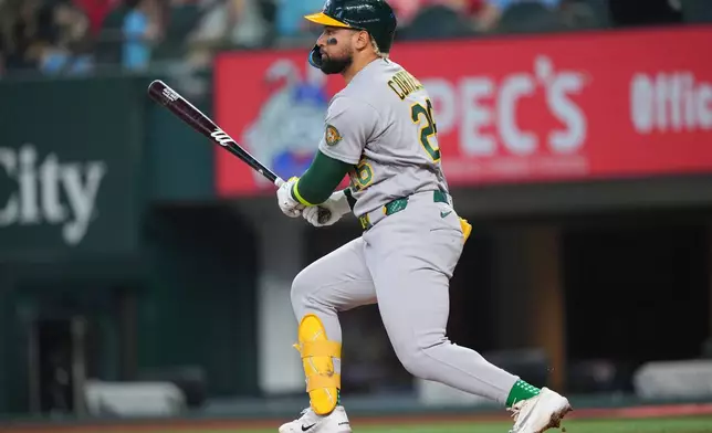 Athletics' Carlos Cortes watches his ball as he collects a single against the Texas Rangers during the fourth inning of a baseball game Sunday, April 26, 2026, in Arlington, Texas. (AP Photo/Julio Cortez)