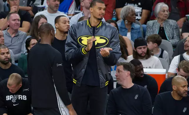 San Antonio Spurs center Victor Wembanyama watches play from the bench during the first half of an NBA basketball game against the Portland Trail Blazers, Wednesday, April 8, 2026, in San Antonio. (AP Photo/Darren Abate)