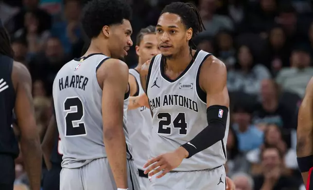 San Antonio Spurs guard Devin Vassell (24) celebrates a basket with teammate Dylan Harper during the first half of their NBA basketball game against the Portland Trail Blazers, Wednesday, April 8, 2026, in San Antonio. (AP Photo/Darren Abate)