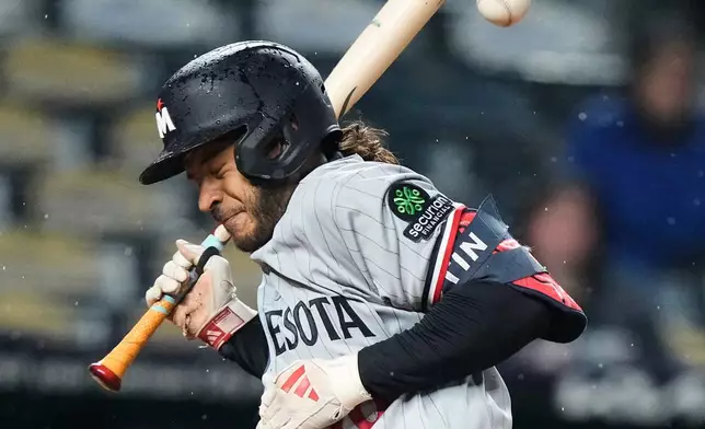 Minnesota Twins' Austin Martin reacts after being hit by a pitch thrown by Kansas City Royals relief pitcher Alex Lange to score a run during the eighth inning of a baseball game Wednesday, April 1, 2026, in Kansas City, Mo. (AP Photo/Charlie Riedel)