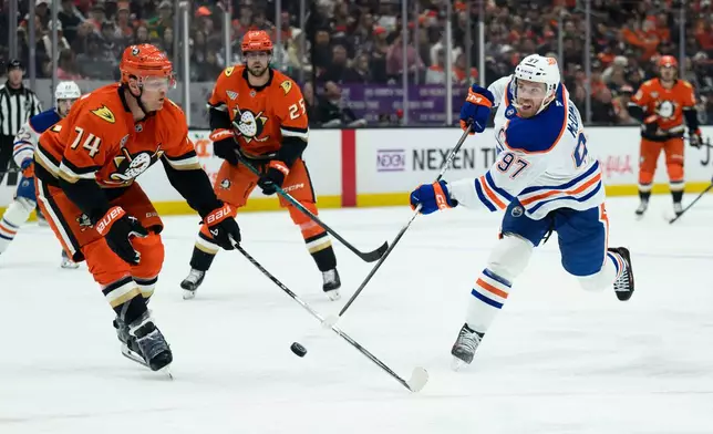 Edmonton Oilers center Connor McDavid, right, shoots as Anaheim Ducks defenseman John Carlson, left, defends during the second period of Game 4 in the first round of an NHL hockey Stanley Cup playoff series Sunday, April 26, 2026, in Anaheim, Calif. (AP Photo/Kyusung Gong)