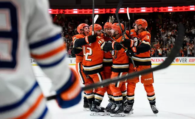 Anaheim Ducks players celebrate a goal by left wing Jeffrey Viel during the third period of Game 4 in the first round of an NHL hockey Stanley Cup playoff series against the Edmonton Oilers, Sunday, April 26, 2026, in Anaheim, Calif. (AP Photo/Kyusung Gong)