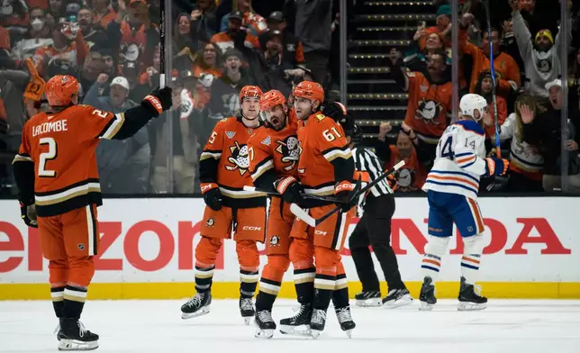 Anaheim Ducks players celebrate a goal by left wing Cutter Gauthier (61) during the second period of Game 4 in the first round of an NHL hockey Stanley Cup playoff series against the Edmonton Oilers, Sunday, April 26, 2026, in Anaheim, Calif. (AP Photo/Kyusung Gong)