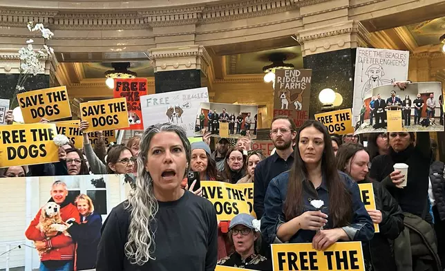 Rebekah Robinson, the president of Dane4Dogs, center left, speaks at a protest at the Wisconsin State Capitol demanding that the governor and attorney general do what they can to shut down a beagle breeding and research facility, Monday, April 20, 2026, in Madison, Wis. (AP Photo/Scott Bauer)