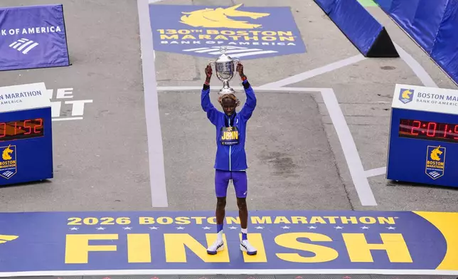 John Korir of Kenya, hoist the trophy after winning the Boston Marathon, Monday, April 20, 2026, in Boston. (AP Photo/Charles Krupa)