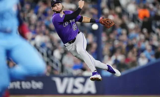 Colorado Rockies third baseman Kyle Karros (12) throws to first base during third inning of a baseball game against the Toronto Blue Jays in Toronto on Tuesday, March 31, 2026. (Nathan Denette/The Canadian Press via AP)