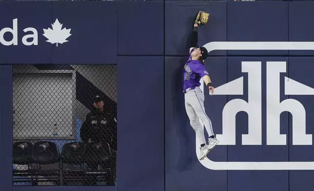 Colorado Rockies outfielder Jake McCarthy (31) can't make the catch on an RBI double by Toronto Blue Jays' Ernie Clement during the seventh inning of a baseball game in Toronto on Tuesday, March 31, 2026. (Nathan Denette/The Canadian Press via AP)