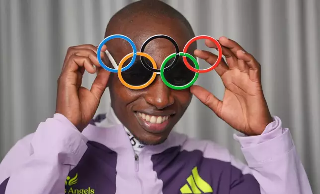 Kenya's Sabastian Sawe poses with Olympic Ring sun-glasses during an interview with The Associated Press after winning the London Marathon, in London, Monday, April 27, 2026. (AP Photo/Kin Cheung)
