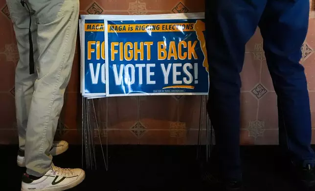 Signs in support of the Virginia redistricting referendum are seen as Jen Strozier and Doug Mock, members of the Goochland Democratic Committee, order lunch at GG's Pizza, Thursday, April 2, 2026, in Maiden, Va. (AP Photo/Julia Demaree Nikhinson)