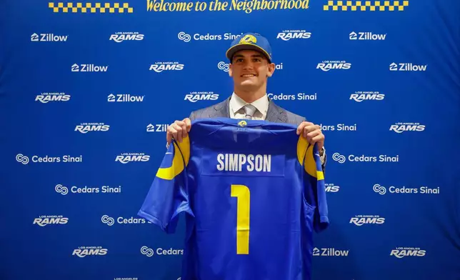 Los Angeles Rams first-round draft pick Ty Simpson holds a jersey during an NFL football news conference Friday, April 24, 2026, in Inglewood, Calif. (AP Photo/Caroline Brehman)
