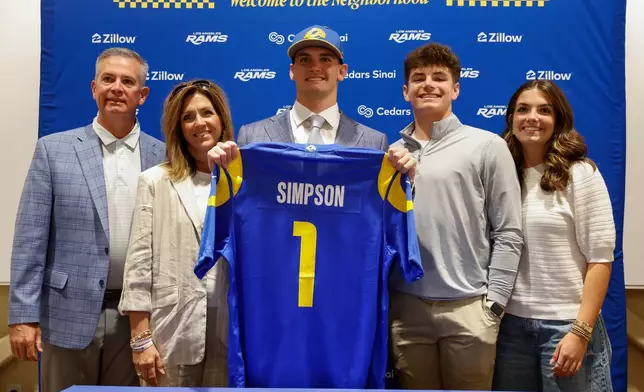 Ty Simpson, selected in the first round of the NFL football draft by the Los Angeles Rams, poses with family members during a press conference on Friday, April 24, 2026, in Inglewood, Calif. (AP Photo/Caroline Brehman)